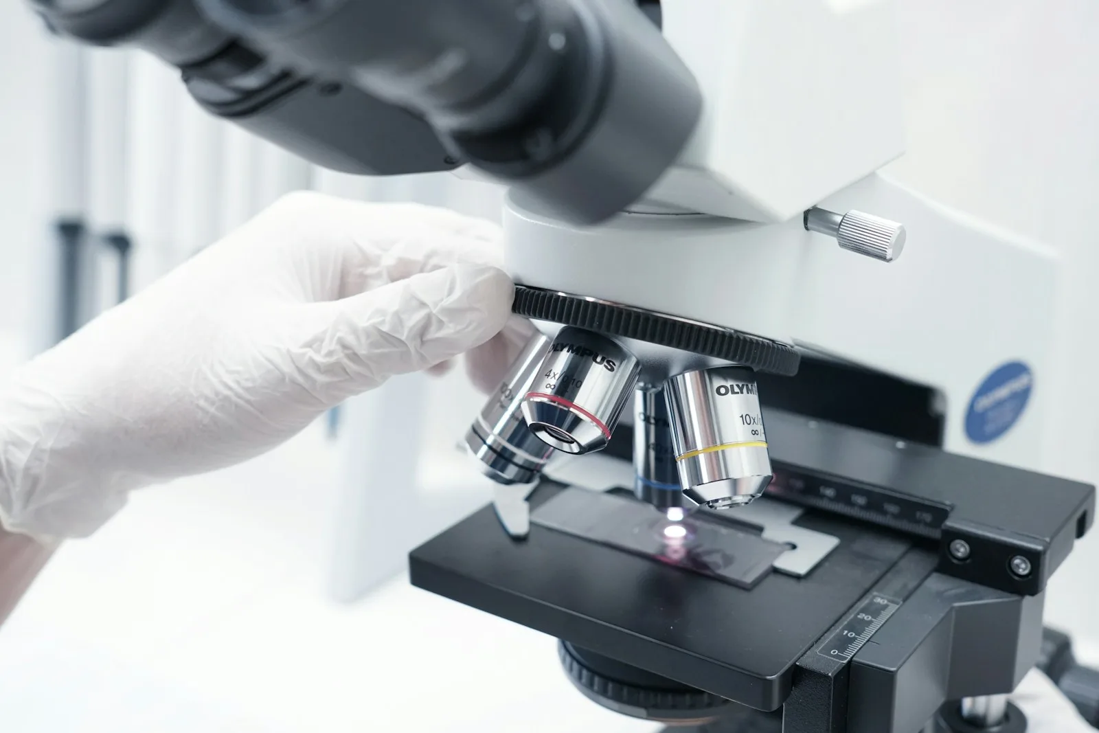 Close-up of a person using a microscope to examine a biopsy slide.